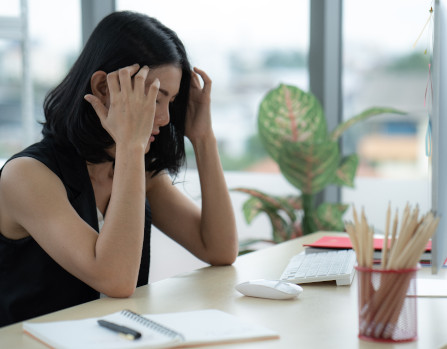 Riesgos laborales egresados Mujer con dolor de cabeza